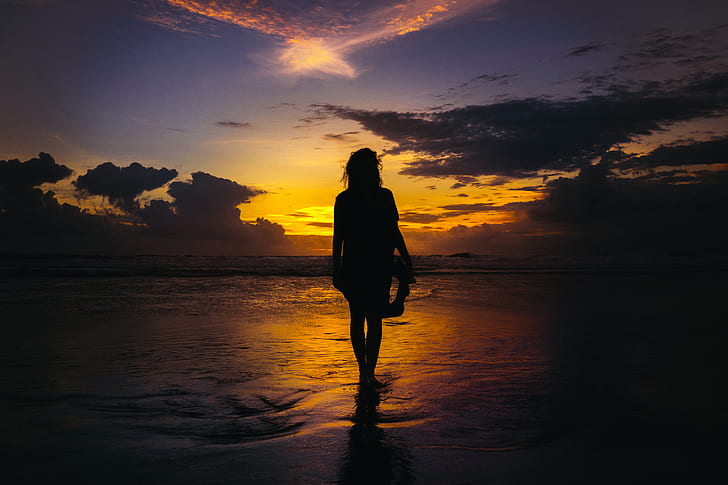 photo of woman near seashore near golden hour