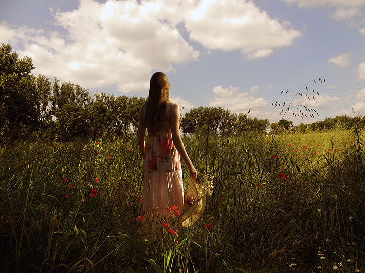 woman in pink and red floral dress on green grass