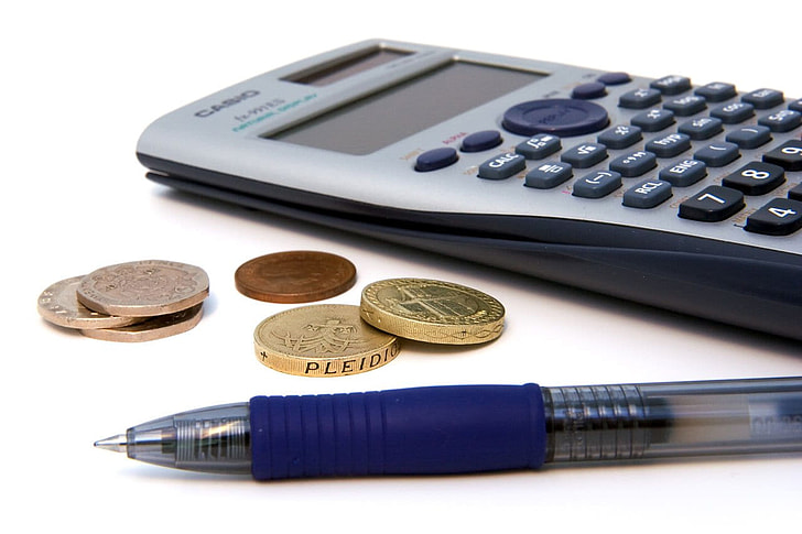 pen near coins and calculator