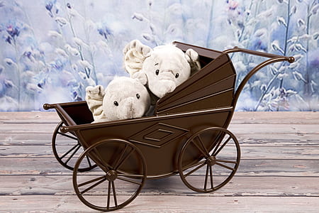 two white animal plush toys on brown carriage