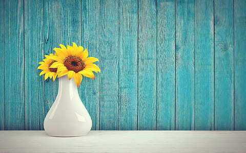 two yellow sunflowers in white ceramic vase
