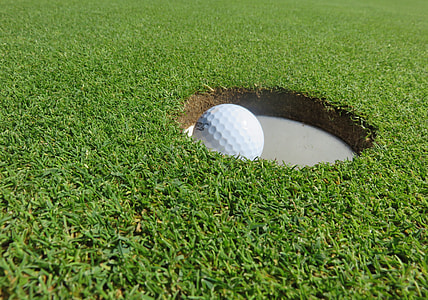 white golf ball on hole during daytime