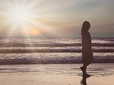 girl silhouette on seashore photo