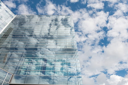 Bottom View of Clear Glass Building Under Blue Cloudy Sky during Day Time