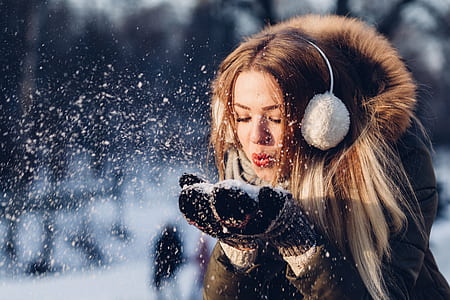 selective focus photo of woman blowing snow