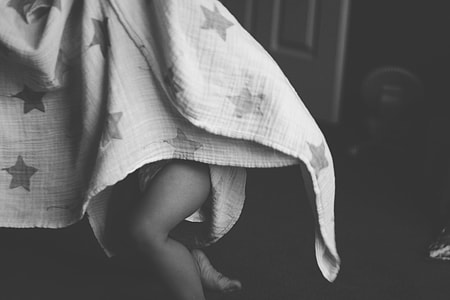 Baby in gray bed sheet