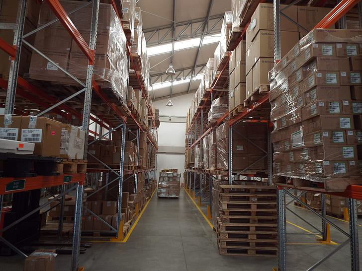cardboard boxes piled on shelves inside warehouse