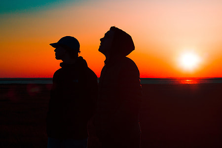 Silhouettes of two men at sunset