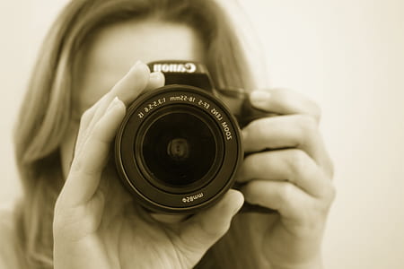 woman holding black Canon camera
