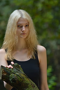 Woman in Black Tank Top While Her Right Hand Is Holding a Tree Branch