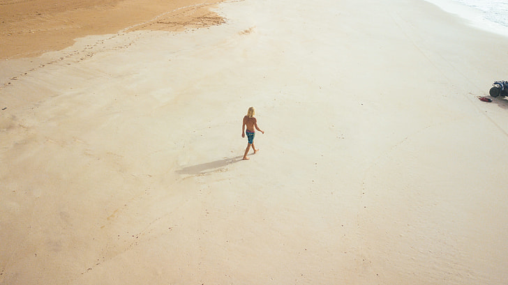person walking on sand in aerial photography