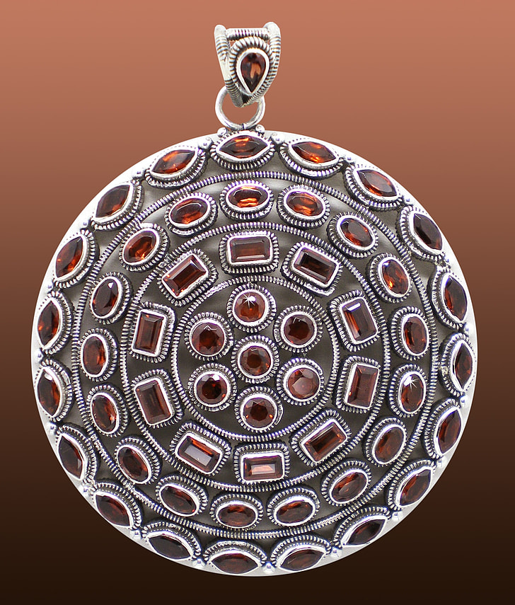 silver-colored and red gemstone pendant
