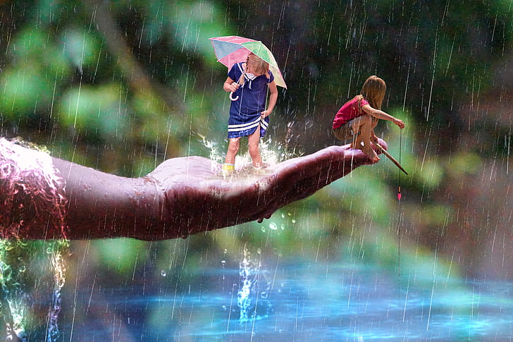 two children's enjoying the rain during daytime