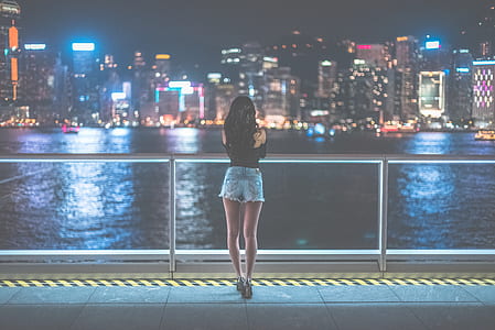 Woman Watching View of Metropolis during Nighttime