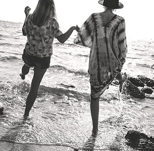 two women standing at seashore