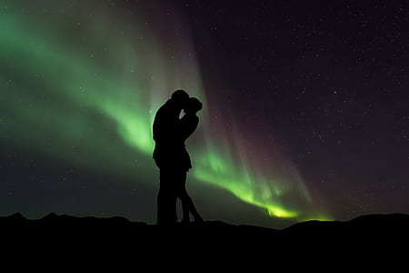 two man and woman kissing on mountain