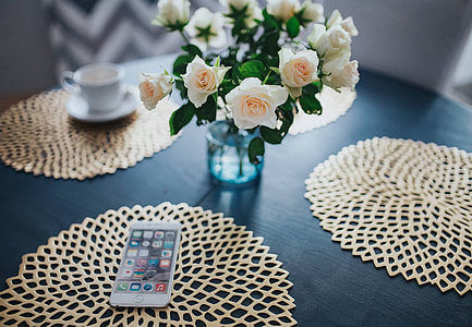 Round breakfast table with white flowers and golden coffee mats