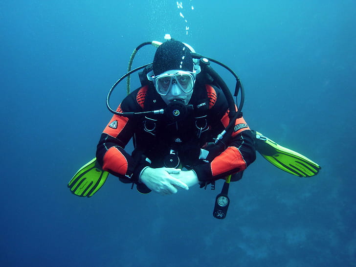 man wearing black and red diving suit underwater