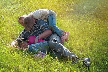 man carrying girl on green grass field