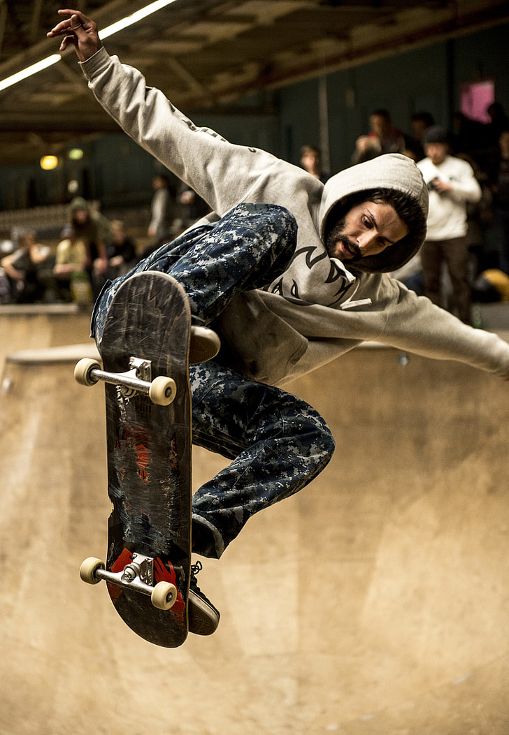 man in gray hoodie riding skateboard