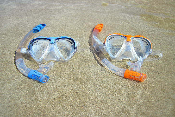 two snorkel and goggles on beach shore