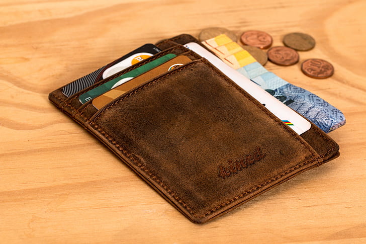 brown leather wallet with banknotes and coin