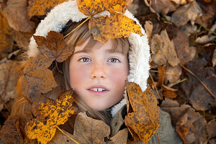 flat lay photography of girl wearing white and gray fur jacket lying on brown leaves