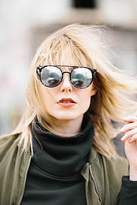 selective photography of woman wearing black turtleneck sweatshirt and round black lens sunglasses