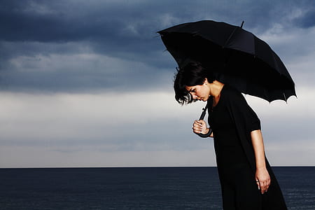 person in black holding a umbrella