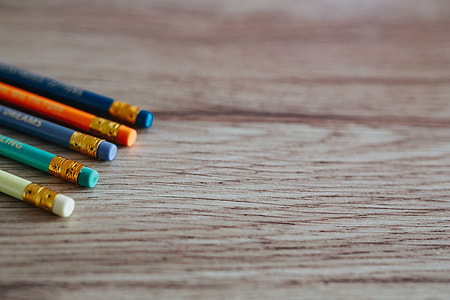 Notebooks with colourful pencils on a wooden desk