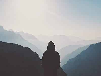 silhouette person standing on mountain during daytime