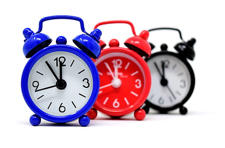 three blue, red, and black twin bell alarm clocks