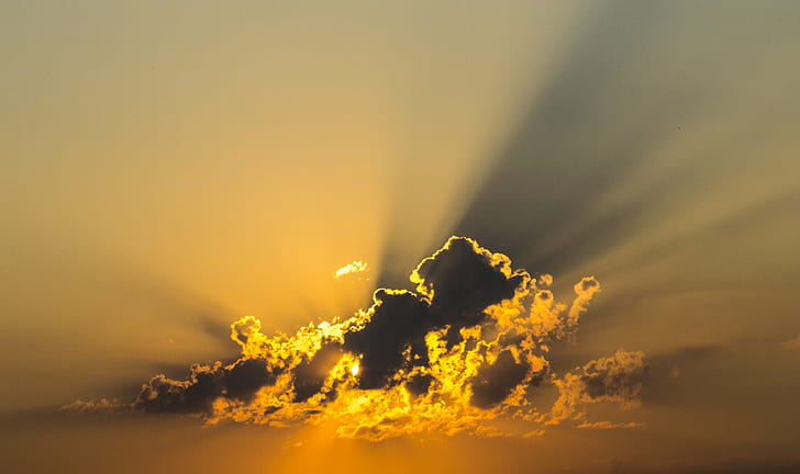 sun covered by clouds emitting sun ray
