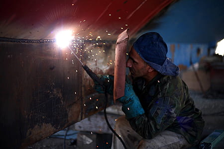 man using welding machine on metal