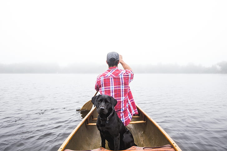 man wearing red and white plaid sport shirt riding boat