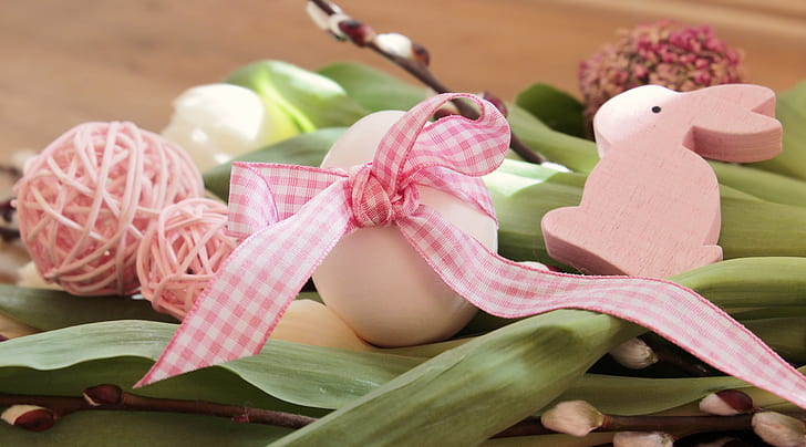 white and pink Easter bunny-themed decoration on green leaf