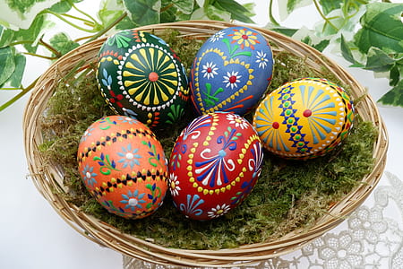 several assorted-color Easter eggs on brown wicker basket