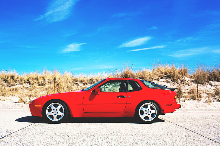 A red sports car sits on the road