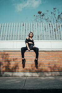 woman in black sports bra sitting on concrete bricks