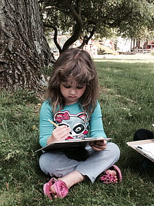 girl writing the under tree