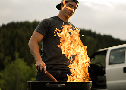 man standing in front of charcoal grill