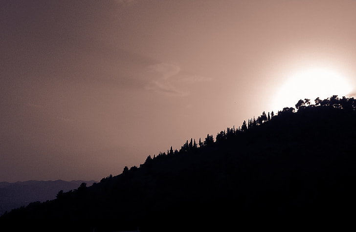 silhouette photography of hill and sunset