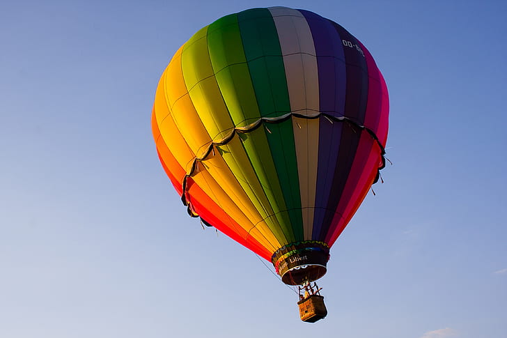 blue, yellow, orange, and red hot-air balloon in flight