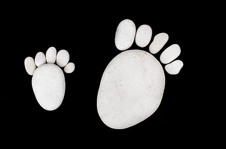 two white foot prints on black background