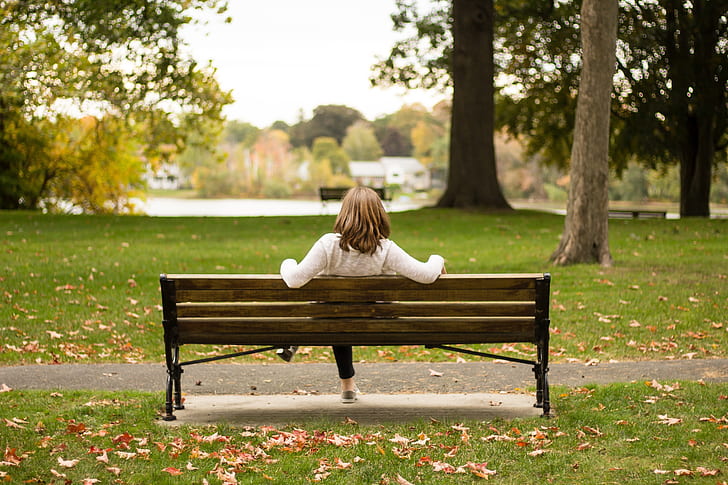 woman sitting on bench at outside park