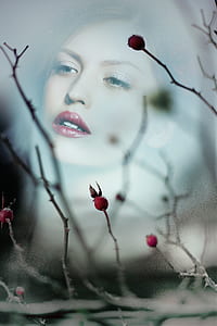 woman in red lipstick and bare tree photo