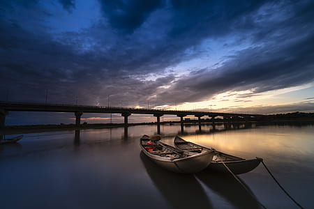 two gray canoes near bridge