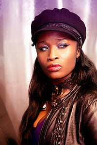woman wearing black leather jacket and purple hat
