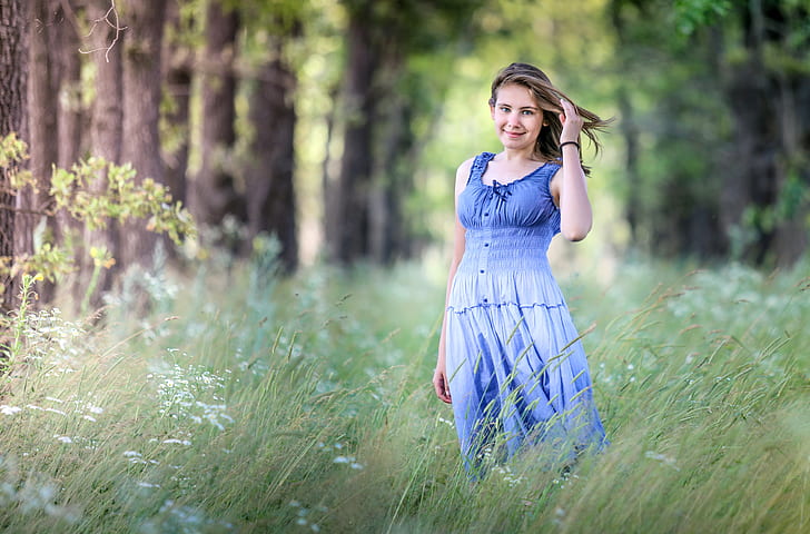 selective photography of woman wearing blue and black tank dress in green grass field