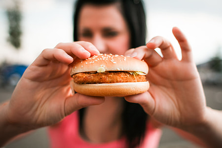 Girl holding Hamburger in her Hands